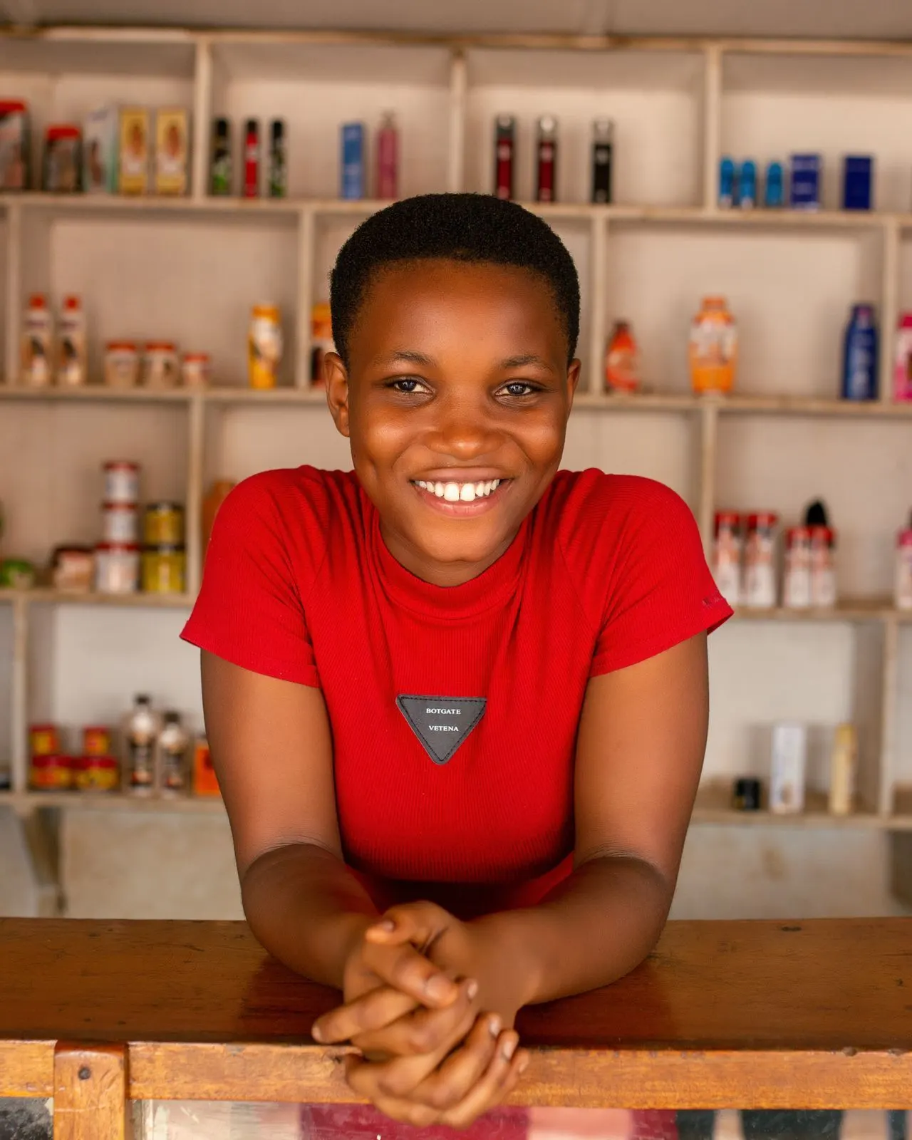 Young smiling shopkeeper behind the counter of her store